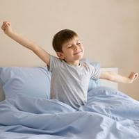 Niño estirándose al despertar